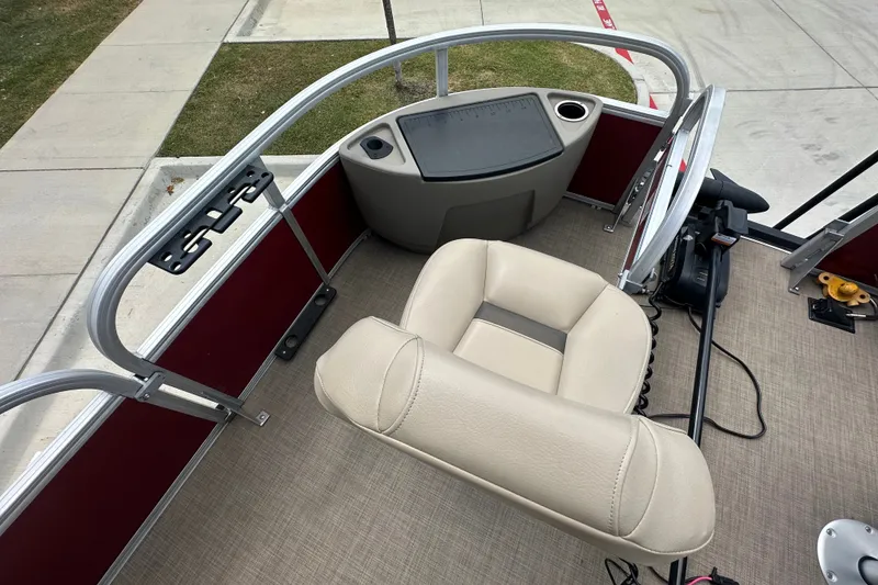 Slide: The Image of 2024 Regency 230 LE3 boat helm with beige captain's chair and steering wheel. - 10