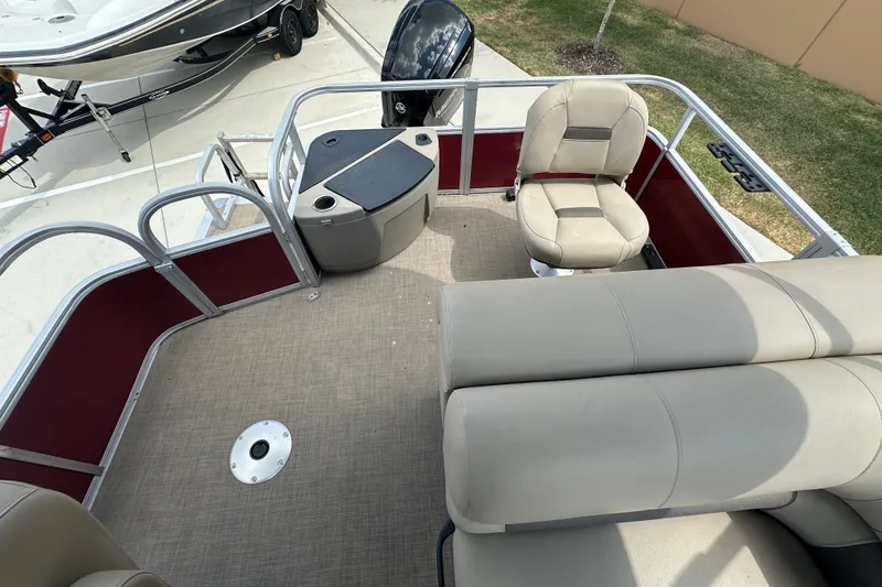 Slide: The Image of 2024 Regency 230 LE3 pontoon boat interior with seating and helm station. - 6