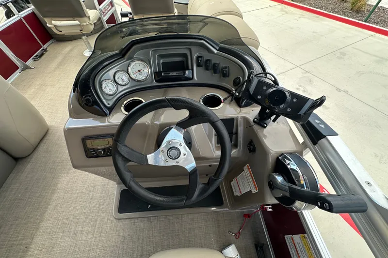 Slide: The Image of 2024 Regency 230 LE3 boat dashboard with steering wheel and control panel. - 9