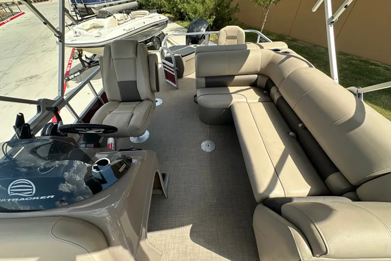 Slide: The Image of 2024 Regency 230 LE3 pontoon boat interior with plush seating and modern helm. - 4