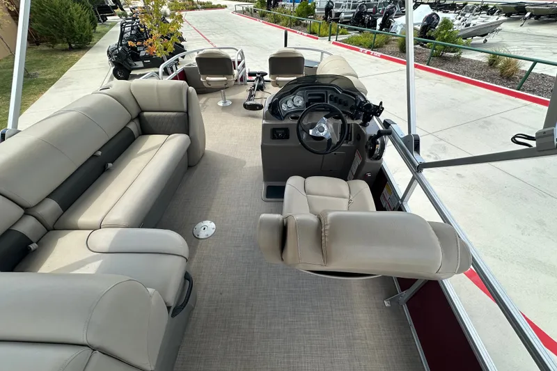 Slide: The Image of 2024 Regency 230 LE3 pontoon boat interior with plush seating and modern helm. - 7