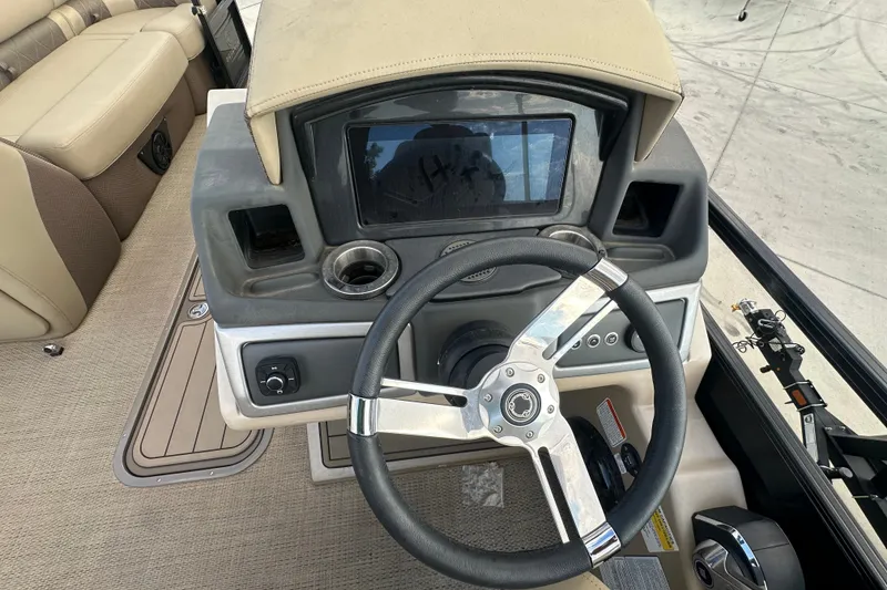 Slide: The Image of 2024 Regency 230 LE3 boat dashboard with steering wheel and control panel. - 18