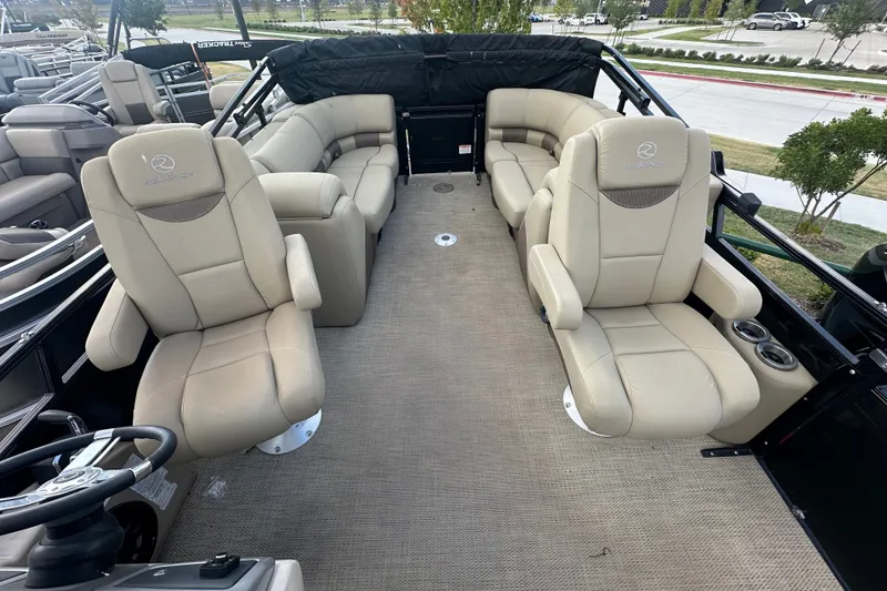 Slide: The Image of 2024 Regency 230 LE3 boat interior with beige seating and steering wheel. - 16
