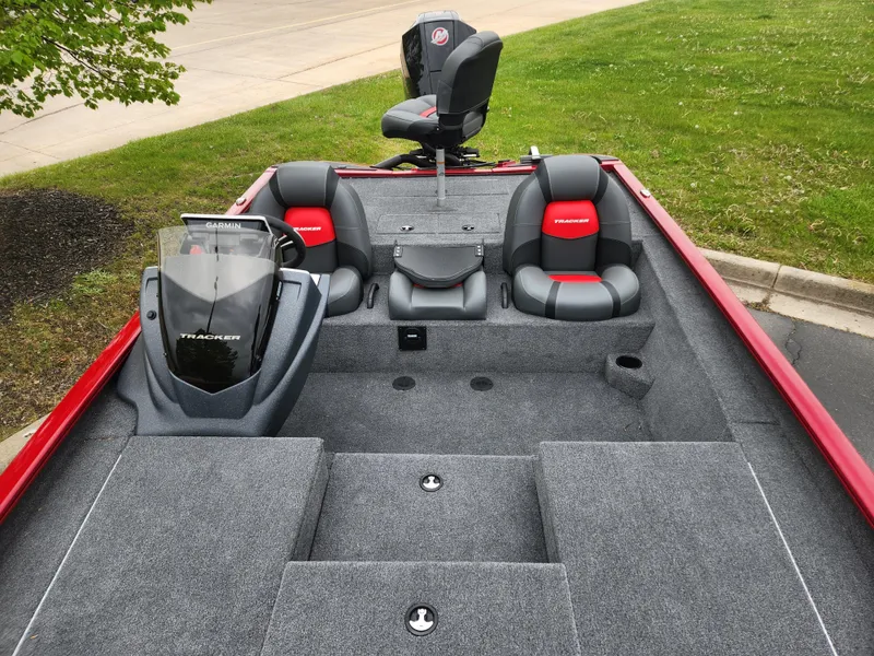 Slide: The Image of 2025 Tracker Savage 215 boat interior with gray and red seating, steering console, and storage compartments. - 3