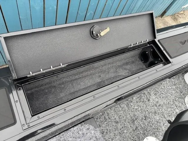 Slide: The Image of 2025 Tracker Targa V-19 Combo boat storage compartment with lock and cup holders. - 19