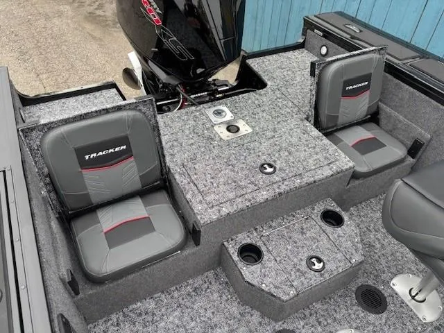 Slide: The Image of 2025 Tracker Targa V-19 Combo boat interior with gray seating and storage compartments. - 21