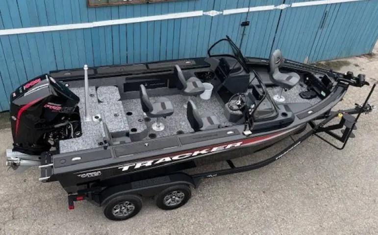 Slide: The Image of 2025 Tracker Targa V-19 Combo boat with seating, trailer, and outboard motor, parked on concrete. - 6