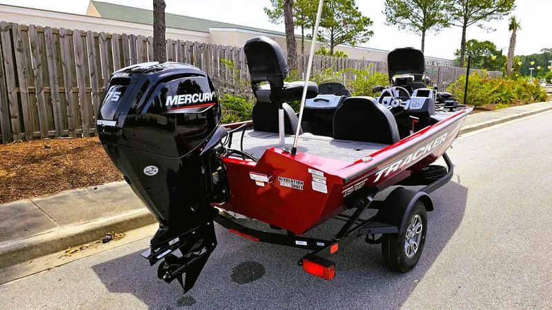 Slide: The Image of 2025 Tracker Pro Team 175 boat with Mercury engine, parked on a street. - 3