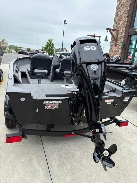 Slide: The Image of 2025 Tracker Super Guide V-16 SC boat with 50 HP motor, parked outdoors. - 4