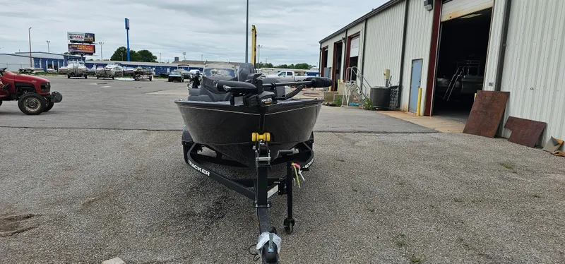 Slide: The Image of 2025 Tracker Super Guide V-16 SC boat on trailer outside a warehouse. - 2