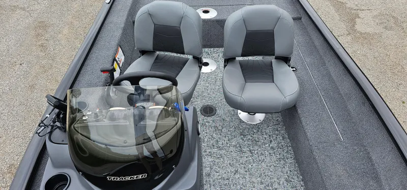 Slide: The Image of 2025 Tracker Super Guide V-16 SC boat interior with two gray seats and steering console. - 5