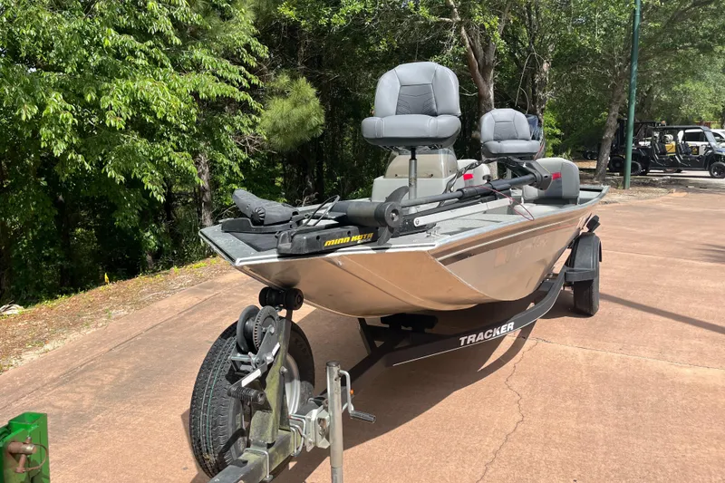 Slide: The Image of 2017 Tracker PRO160 boat on trailer, parked outdoors with trees in the background. - 4