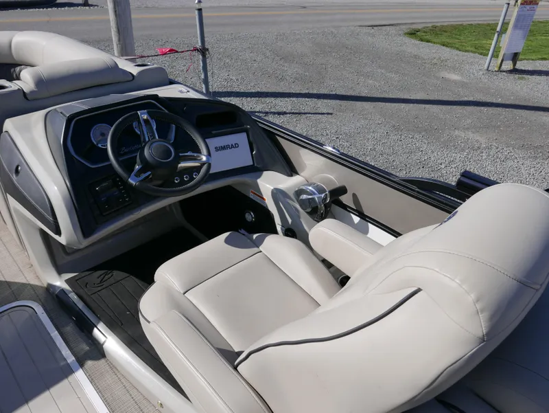 Slide: The Image of 2019 Barletta L23QCSS boat interior with steering wheel and beige seating. - 15