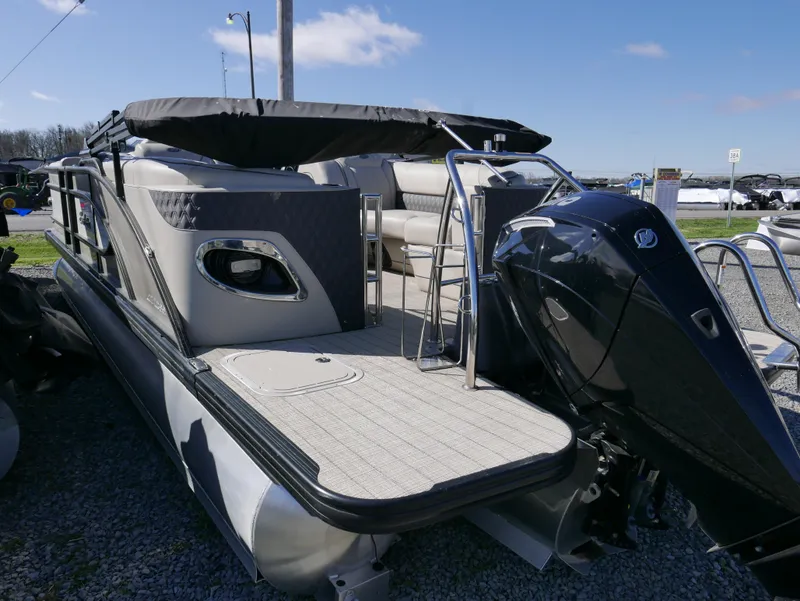 Slide: The Image of 2019 Barletta L23QCSS pontoon boat with outboard motor, parked on gravel. - 9