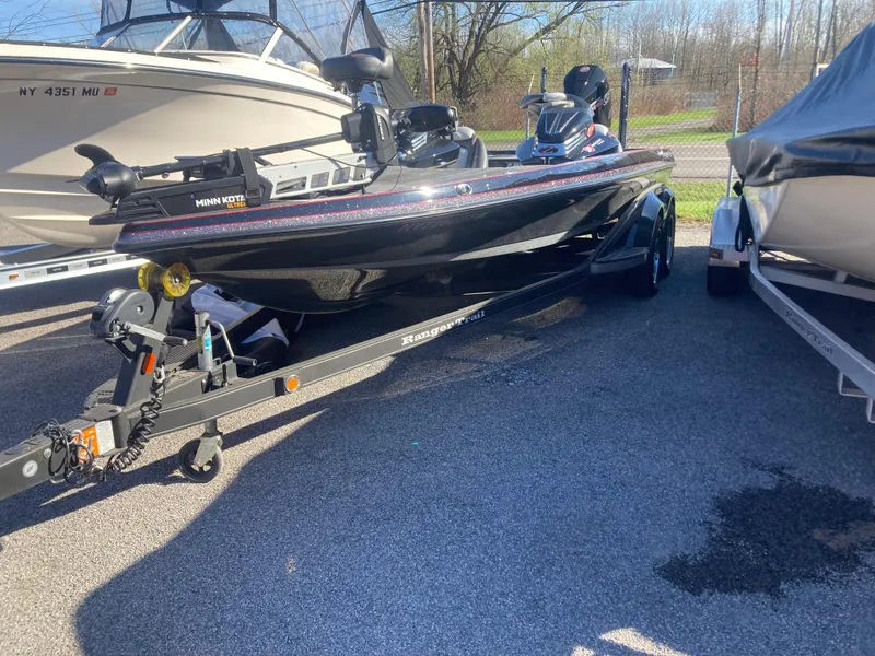 Slide: The Image of 2015 Ranger Z521 Comanche bass boat on trailer, parked between other boats. - 27