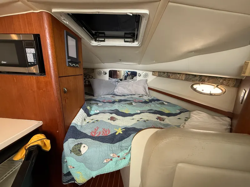 Slide: The Image of 1998 Tiara Yachts 2900 Open cabin with bed, microwave, and porthole window. - 20