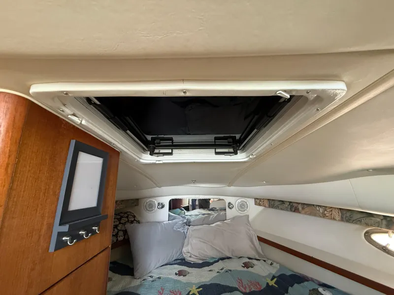 Slide: The Image of Interior cabin of a 1998 Tiara Yachts 2900 Open, featuring a cozy bed and overhead hatch. - 23