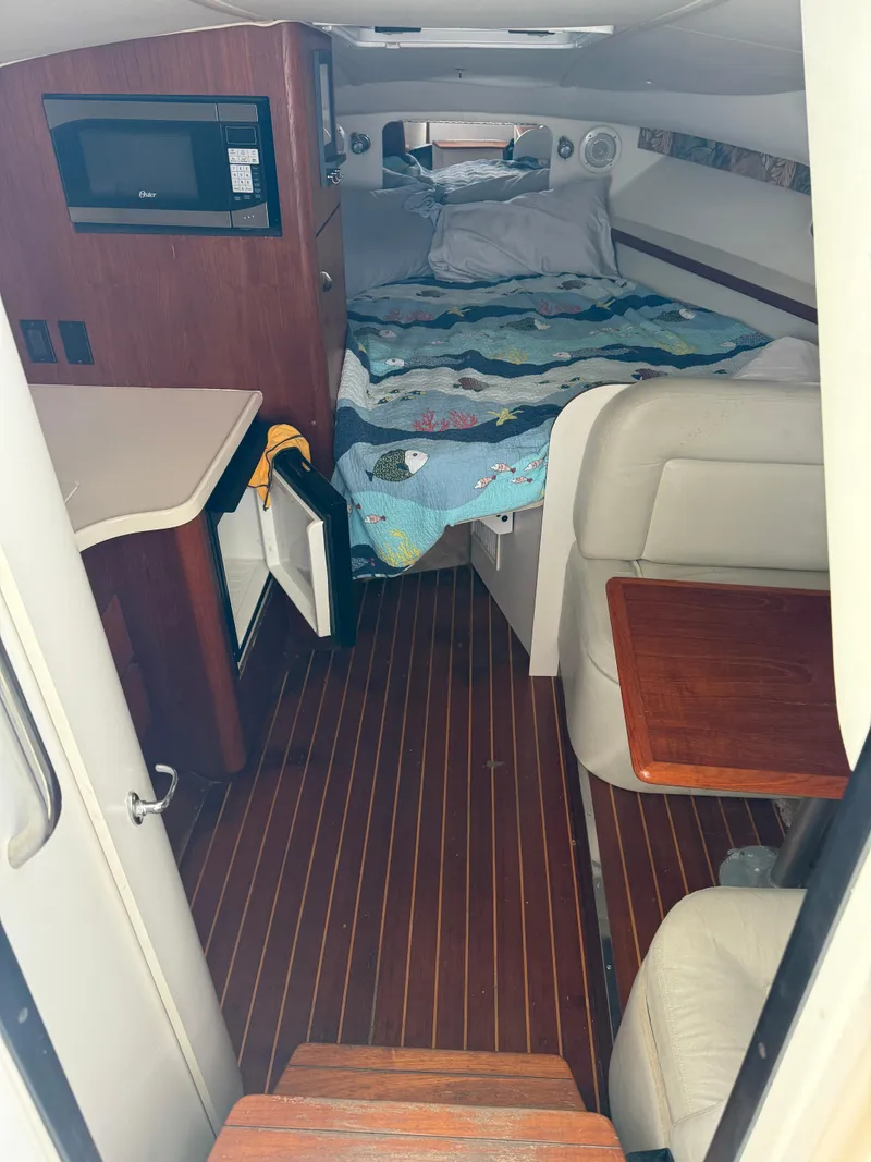 Slide: The Image of 1998 Tiara Yachts 2900 Open cabin interior with bed, seating, and kitchenette. - 25