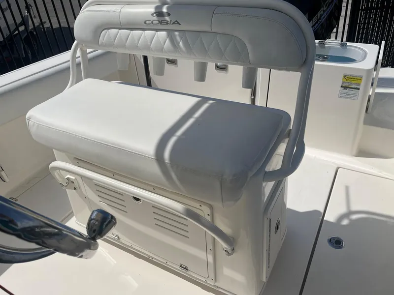 Slide: The Image of 2022 Cobia 237 Center Console boat seat with storage and rod holders. - 10