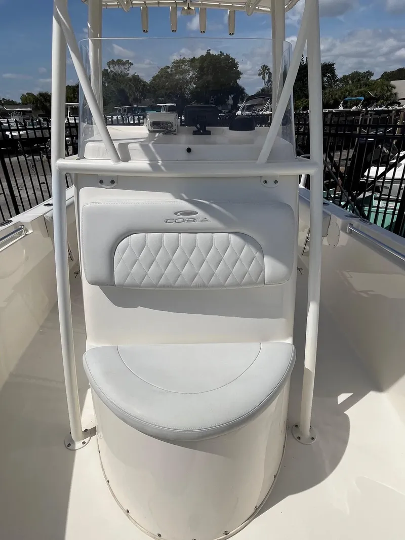 Slide: The Image of 2022 Cobia 237 Center Console boat with white seating and console, docked outdoors. - 11
