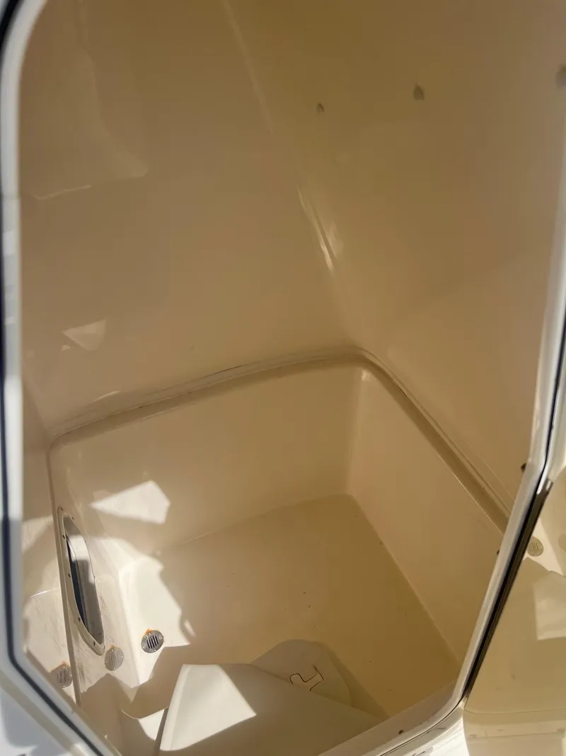 Slide: The Image of 2022 Cobia 237 Center Console interior storage compartment, beige finish. - 14