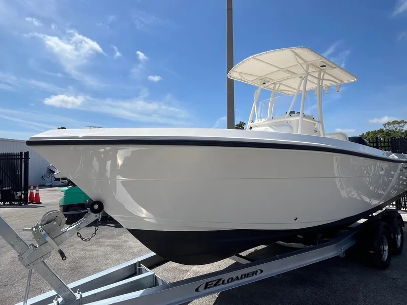 Slide: The Image of 2022 Cobia 237 Center Console boat on trailer under clear blue sky. - 2