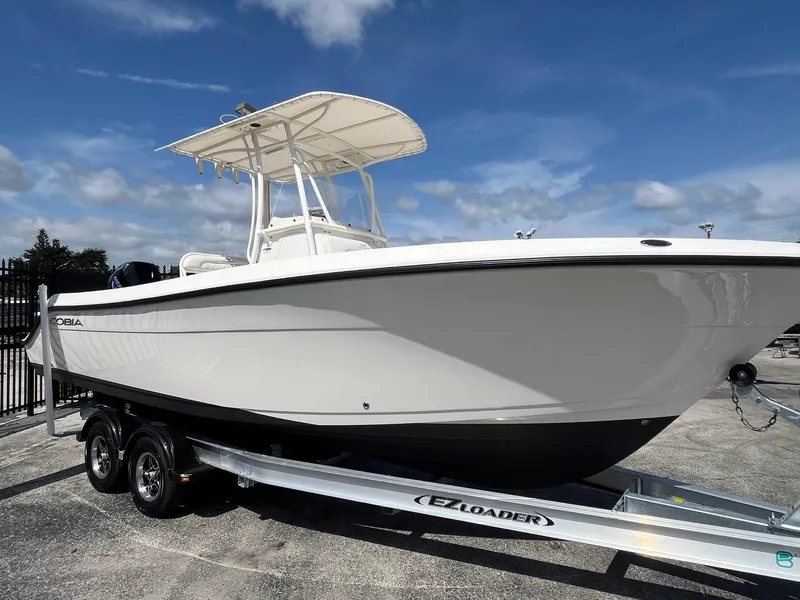 Slide: The Image of 2022 Cobia 237 Center Console boat on trailer under clear blue sky. - 3