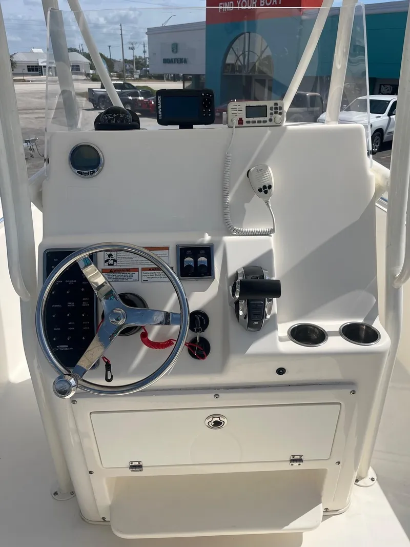 Slide: The Image of 2022 Cobia 237 Center Console boat dashboard with steering wheel and controls. - 6