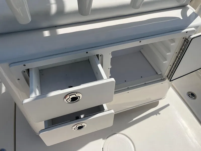 Slide: The Image of Open storage compartments on a 2022 Cobia 237 Center Console boat. - 7