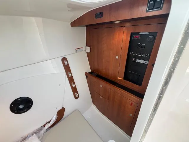 Slide: The Image of 2025 Pursuit DC 326 Dual Console interior with wooden cabinetry and control panel. - 12