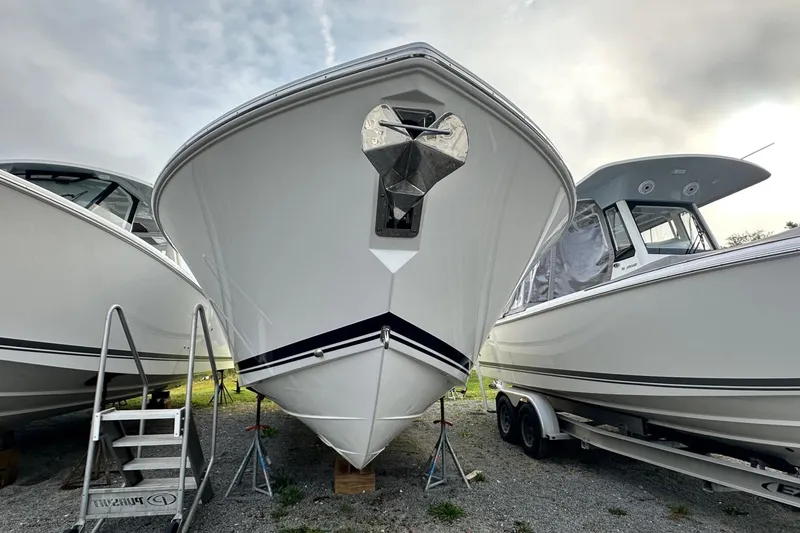 Slide: The Image of 2025 Pursuit DC 326 Dual Console boat on display, front view, with overcast sky. - 16