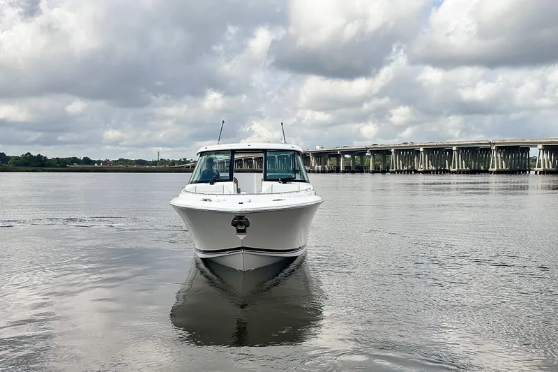 Slide: The Image of 2025 Pursuit DC 326 Dual Console boat on calm water, cloudy sky background. - 4