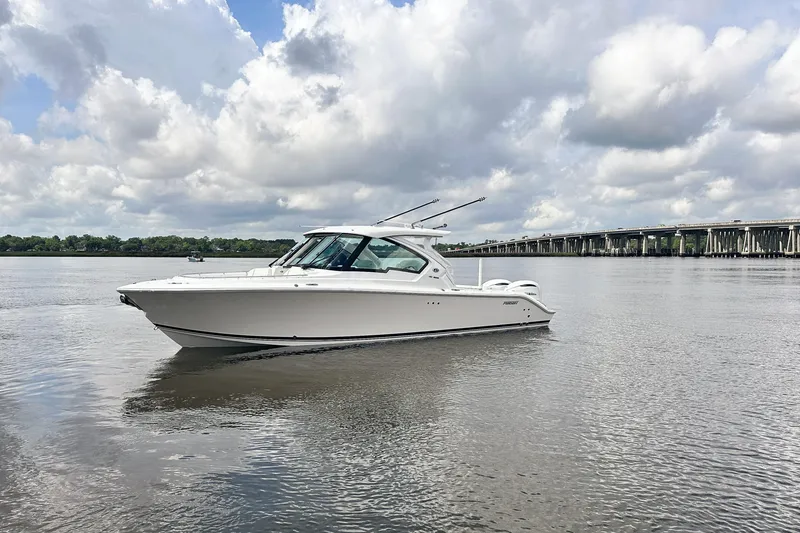 Slide: The Image of 2025 Pursuit DC 326 Dual Console boat on calm water under cloudy sky. - 7