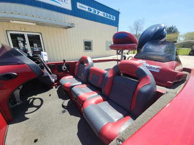 Slide: The Image of 2007 Blazer 190 Pro-V boat interior with red and gray seating, parked outside a building. - 10
