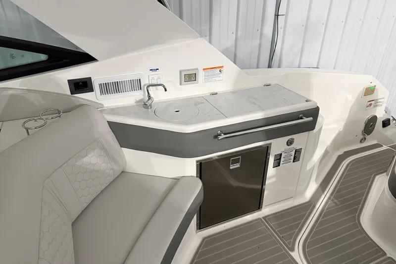 Slide: The Image of 2025 Sea Ray Sundancer 320 interior with kitchenette and seating area. - 20