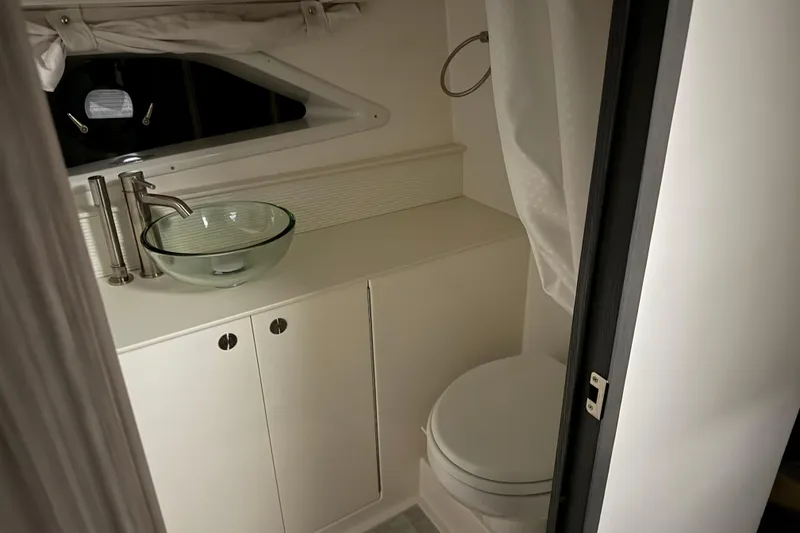 Slide: The Image of 2025 Sea Ray Sundancer 320 bathroom with modern glass sink and sleek fixtures. - 26