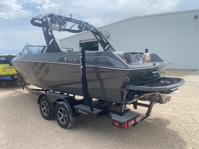 Slide: The Image of 2022 ATX Surf Boats 22 Type-S on trailer, parked outdoors near a large building. - 3