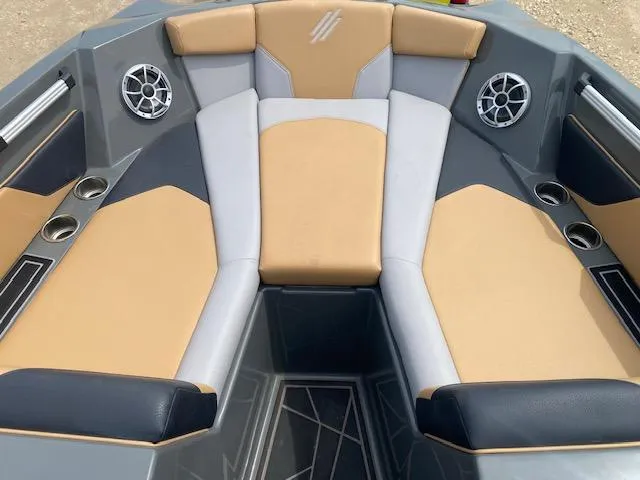 Slide: The Image of 2022 ATX Surf Boats 22 Type-S interior with tan and gray seating, cup holders, and speakers. - 7