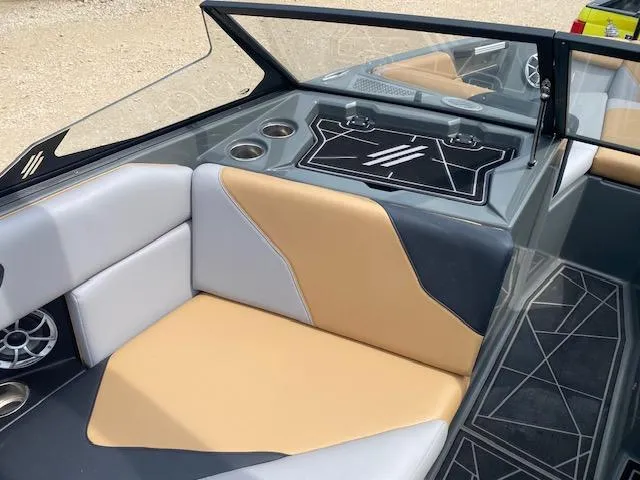 Slide: The Image of 2022 ATX Surf Boats 22 Type-S interior with tan and gray seating, cup holders, and sleek design. - 8