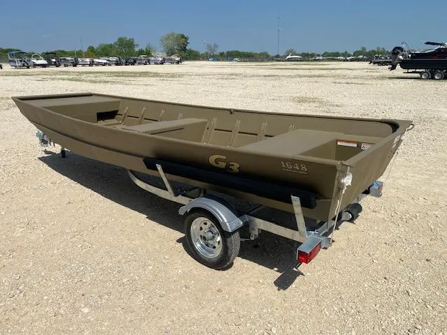 Slide: The Image of 2025 G3 Gator Tough 1648 LW boat on trailer in outdoor setting. - 2