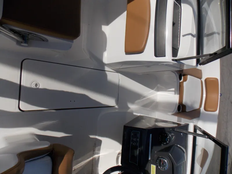 Slide: The Image of 2021 Bayliner VR5 Bowrider OB interior with tan and white seating, dashboard, and storage. - 17