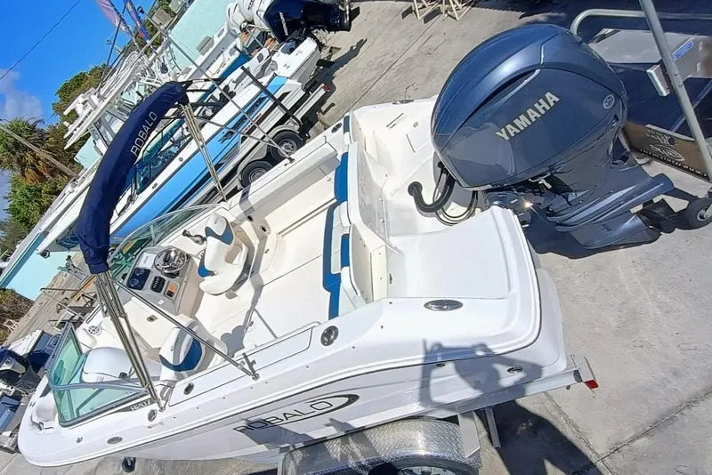 Slide: The Image of 2024 Robalo R207 Dual Console boat with Yamaha engine, docked outdoors. - 2