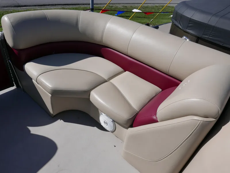 Slide: The Image of 2015 Manitou Oasis boat seating with beige and maroon upholstery, featuring a curved design. - 12