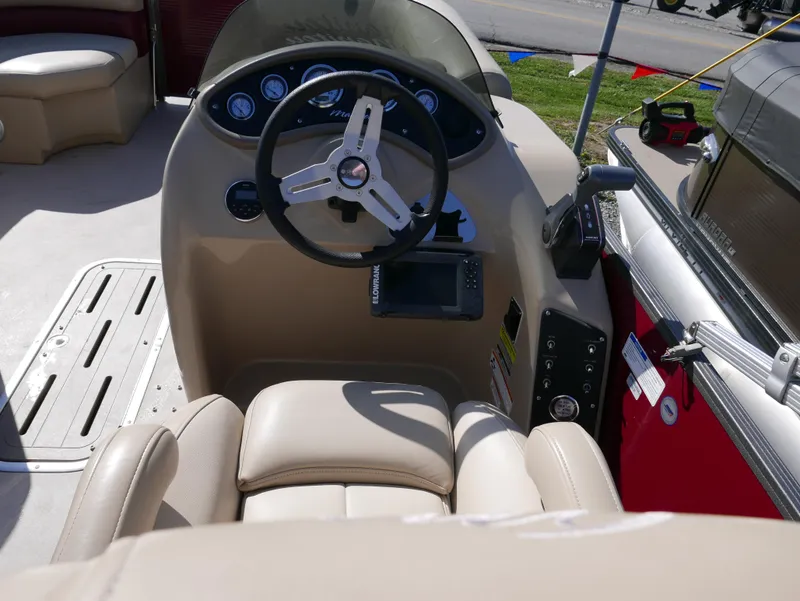 Slide: The Image of 2015 Manitou Oasis boat dashboard with steering wheel and control panel. - 15