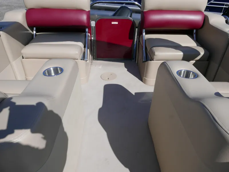 Slide: The Image of Interior of a 2015 Manitou Oasis boat with beige and red seating. - 18