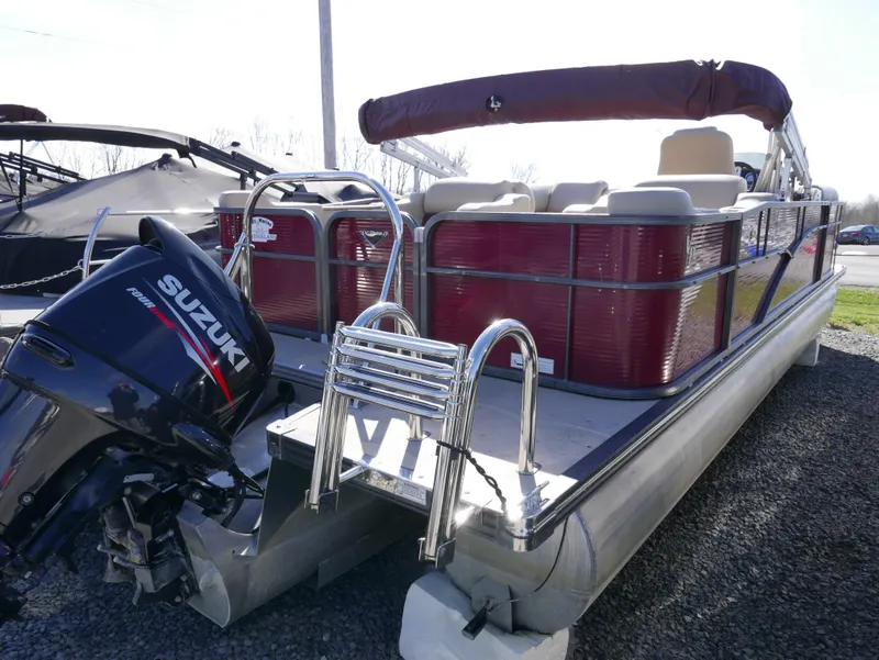 Slide: The Image of 2015 Manitou Oasis pontoon boat with Suzuki outboard motor, docked on gravel. - 9