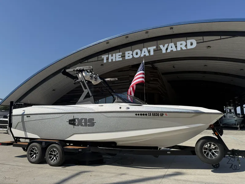 Slide: The Image of 2021 Axis A24 boat on trailer at The Boat Yard, American flag displayed. - 1