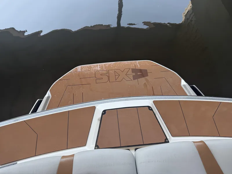 Slide: The Image of 2021 Axis A24 boat swim platform with brown and white design near water. - 10