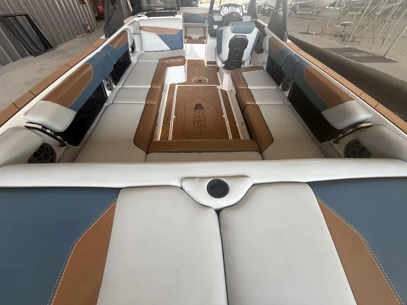 Slide: The Image of 2021 Axis A24 boat interior with brown, blue, and white seating, showcasing spacious design. - 11