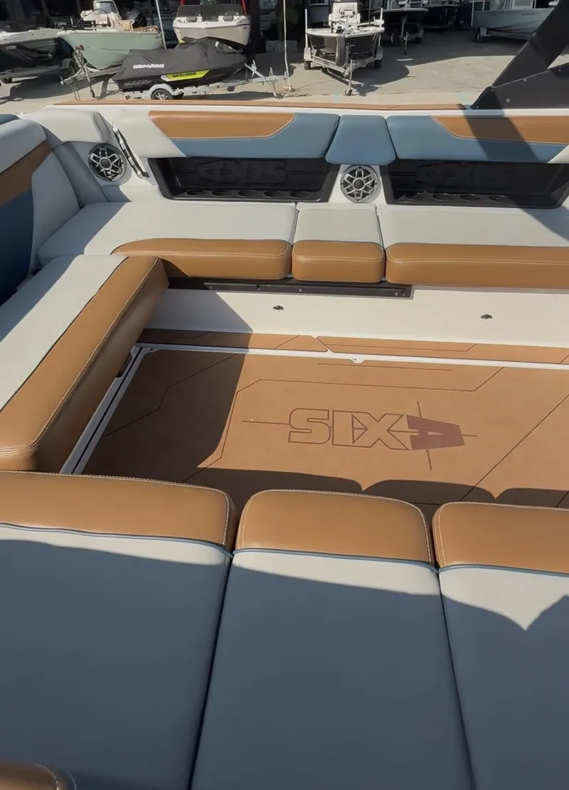 Slide: The Image of 2021 Axis A24 boat interior with tan and gray seating, featuring built-in speakers. - 13